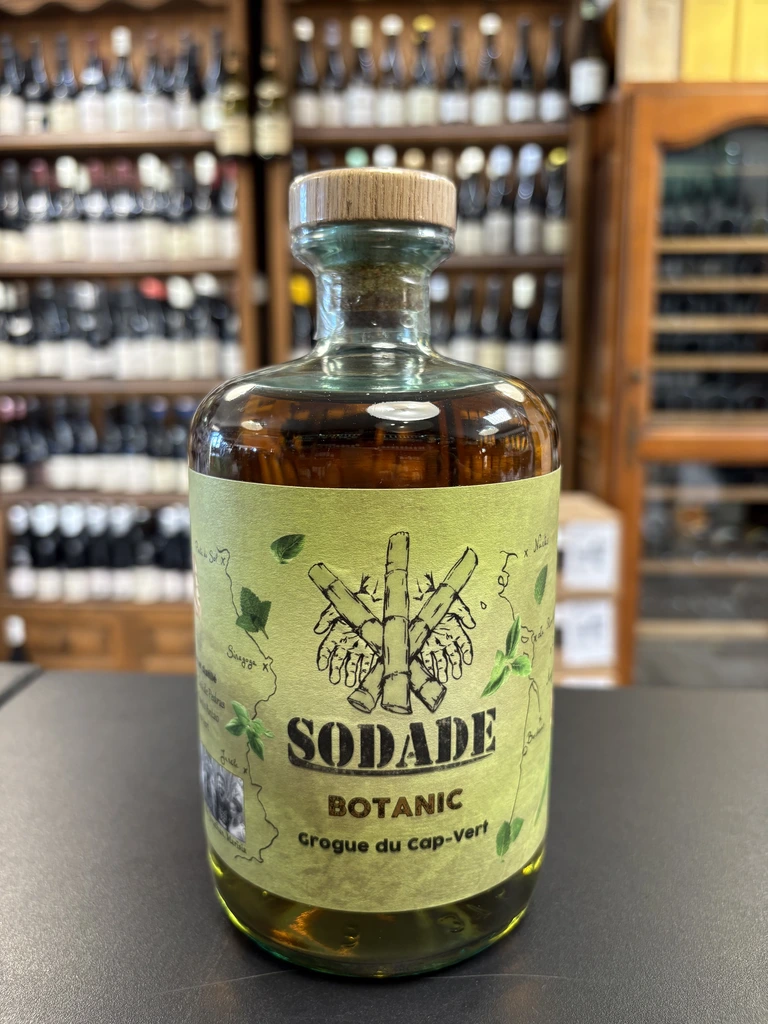Bouteille de Sodade Botanic, grogue botanique du Cap-Vert, avec une étiquette verte illustrée de canne à sucre et de plantes.